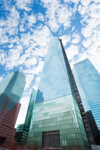 Low angle view of modern buildings against cloudy sky