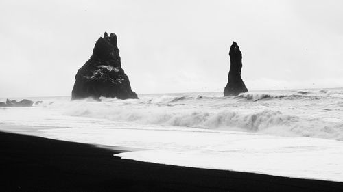 Rocks on beach against sky
