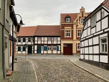 Empty street amidst buildings against sky