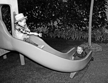 Rear view of woman lying down in yard