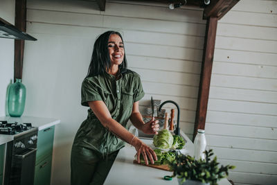 Smiling young woman standing at home