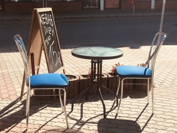 Empty chairs and tables in city