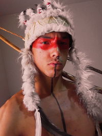 Portrait of shirtless young man wearing headdress