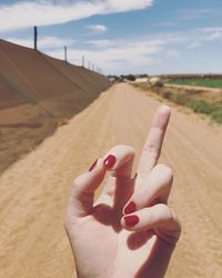 Midsection of person hand holding land against sky