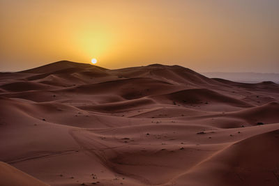 Scenic view of desert against sky during sunset