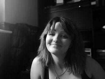 Portrait of smiling mid adult woman sitting at home