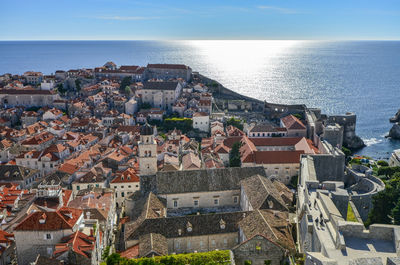 High angle view of townscape by sea against sky