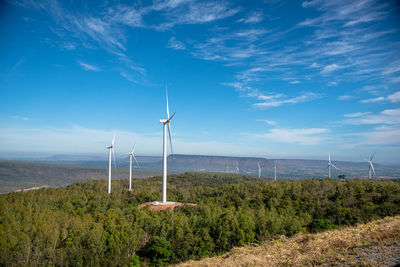 Wind turbines on land against sky