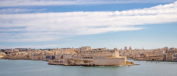 Buildings in city against cloudy sky