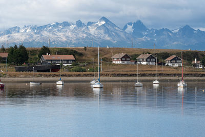 Scenic view of lake by snowcapped mountains against sky