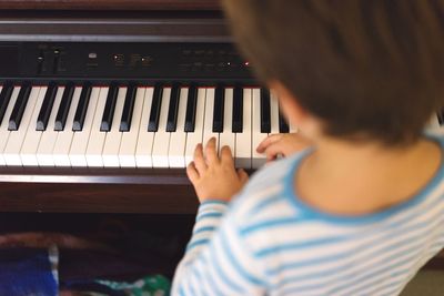 High angle view of boy playing piano at home