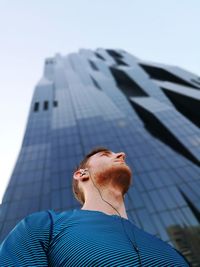 Low angle view of man on office building against sky