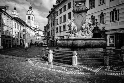 Statues on street amidst buildings in city