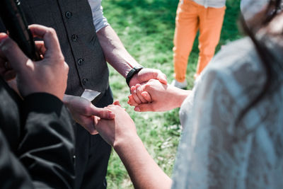 Midsection of people holding hands