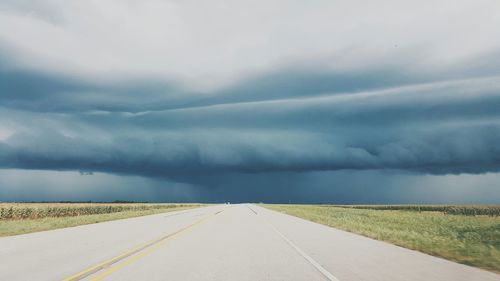 Empty road against cloudy sky