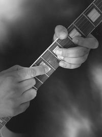 Midsection of man playing guitar