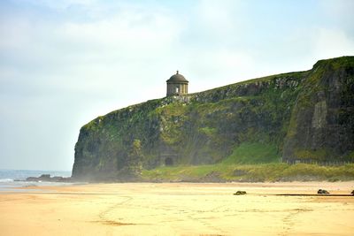 Lighthouse by sea against sky