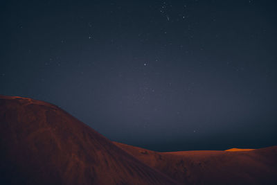 Scenic view of snowcapped mountains against sky at night