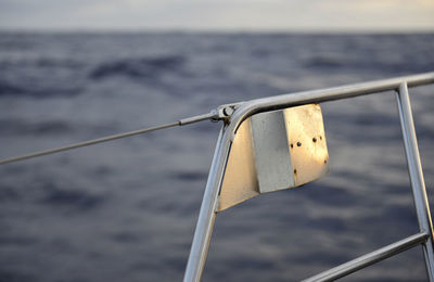 Close-up of metal railing against sea