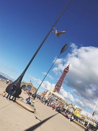 Low angle view of amusement park ride against blue sky