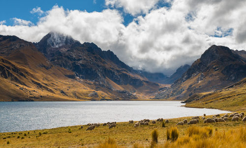 Scenic view of lake by mountains against sky