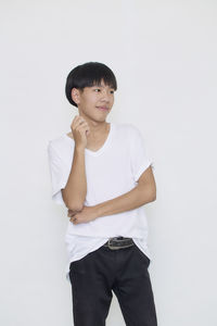 Portrait of young man standing against white background