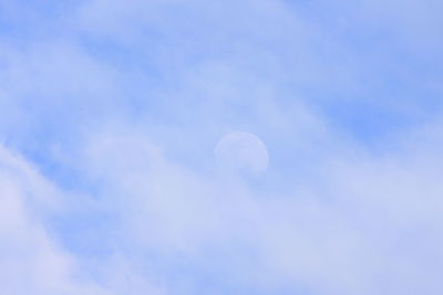 Low angle view of moon against blue sky