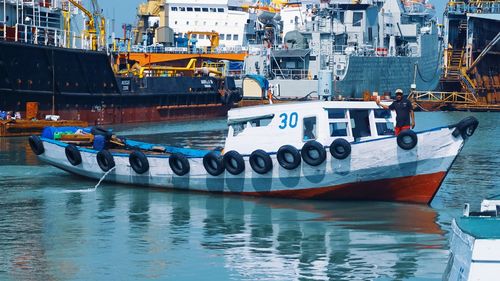 Boats moored at harbor in city