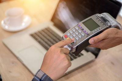 High angle view of man using smart phone on table