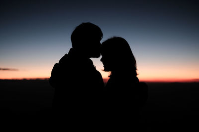 Silhouette woman looking at sunset