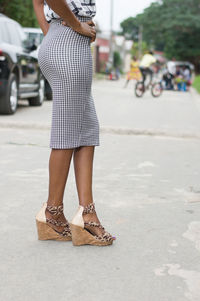 Low section of woman standing on road