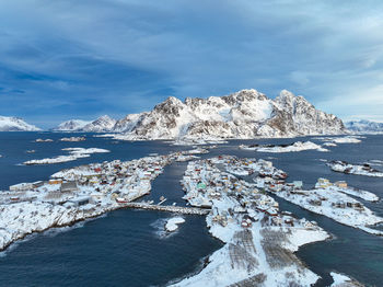 Aerial view of townscape by sea against sky