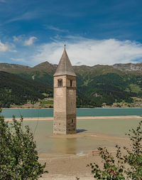 Scenic view of building by mountains against sky