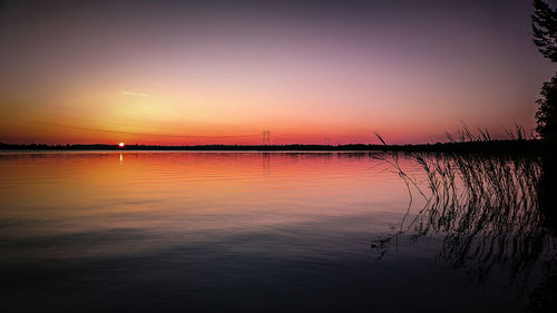 Scenic view of lake against romantic sky at sunset