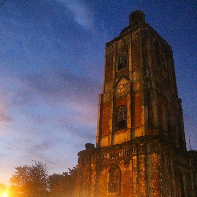 architecture, building exterior, built structure, low angle view, church, sky, religion, place of worship, tower, clock tower, spirituality, blue, history, outdoors, clock, no people, sunset, dusk