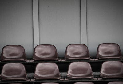 Close-up of empty chairs against wall