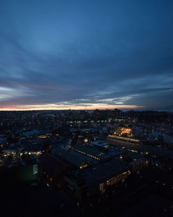 High angle view of illuminated city against sky at dusk