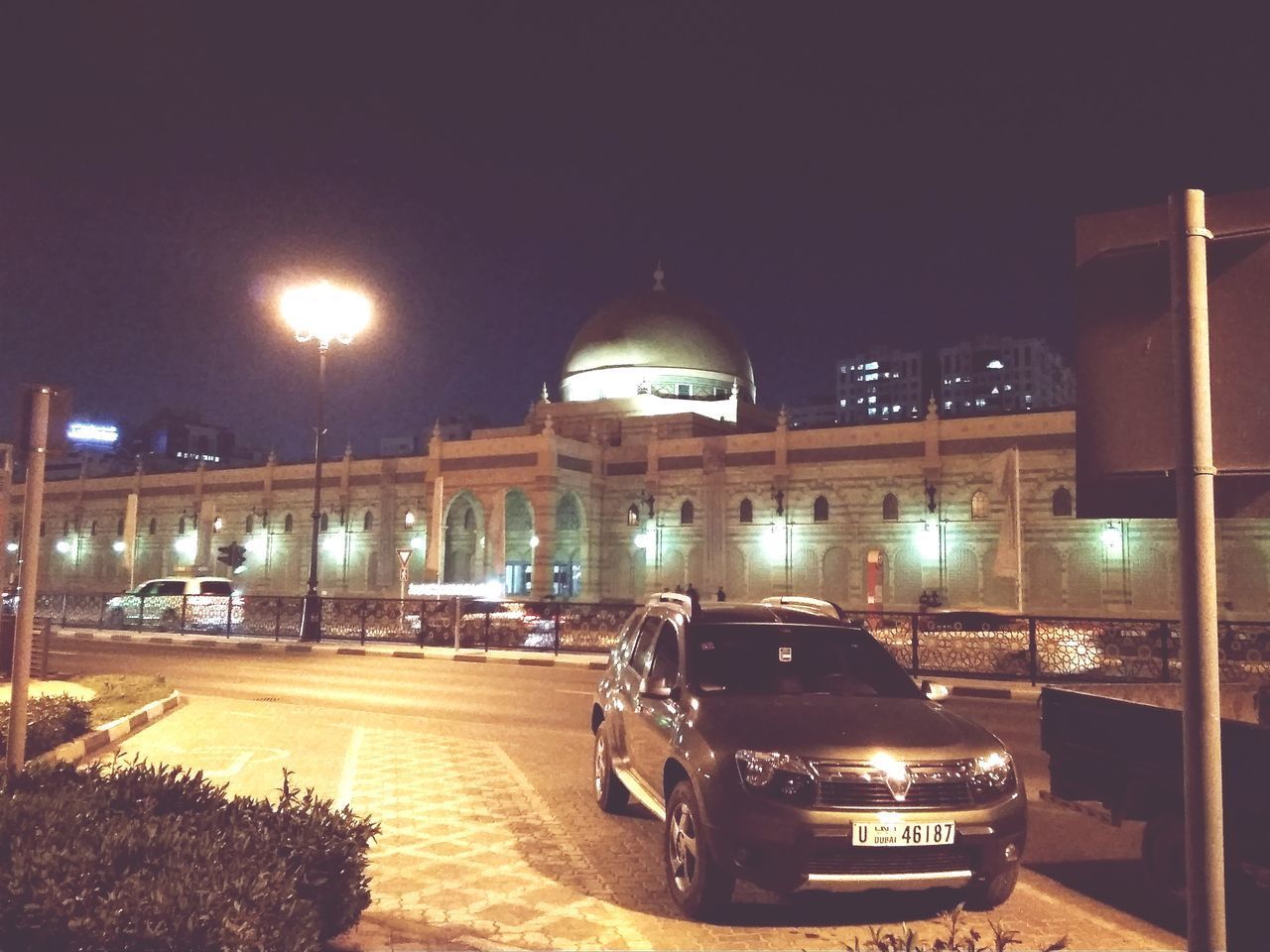 CARS ON ILLUMINATED CITY AT NIGHT