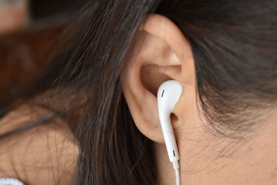 Close-up of woman with headphones in ear
