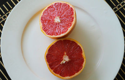 Directly above shot of halved blood oranges on plate