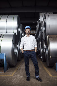 Full length portrait of young man standing in machine