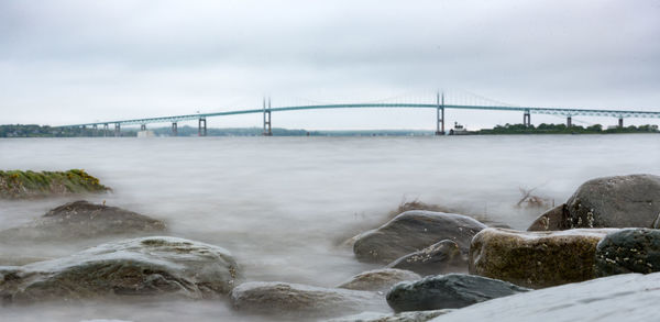 View of bridge over river against cloudy sky