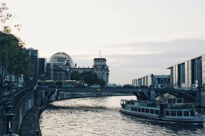 Bridge over river against buildings in city