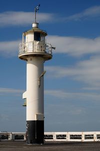 Lighthouse by sea against sky