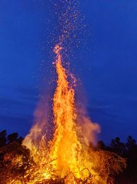 Low angle view of bonfire against blue sky