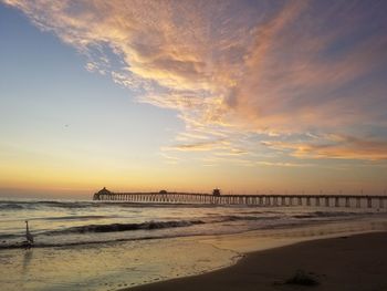 Pier over sea against sky during sunset