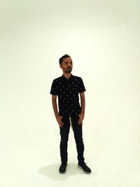 Portrait of young man standing against white background