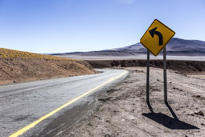 Empty road and sign against sky at atacama desert