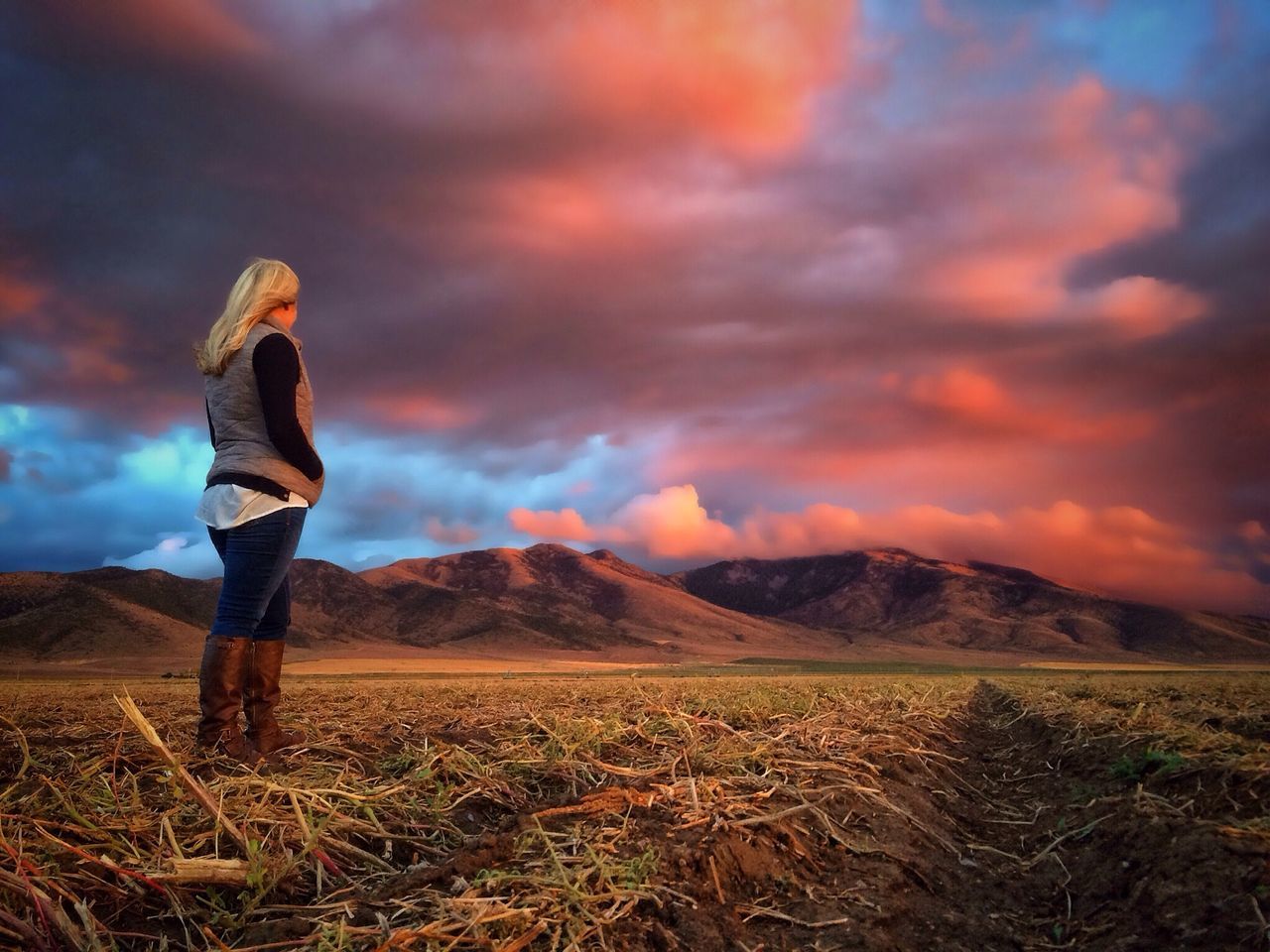 sky, landscape, mountain, tranquil scene, cloud - sky, standing, tranquility, lifestyles, scenics, leisure activity, beauty in nature, nature, rear view, mountain range, field, sunset, casual clothing, cloud