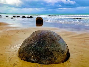 Scenic view of rocks on beach against sky